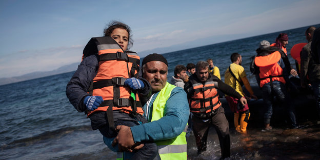 Flüchtlinge kommen auf einem Boot an.