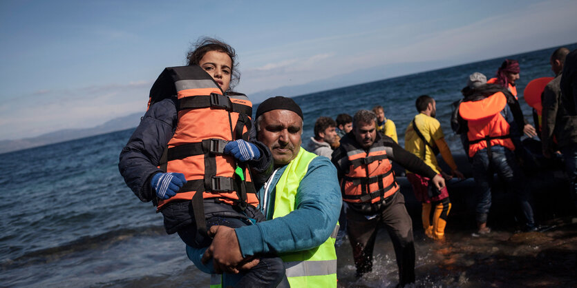 Flüchtlinge kommen auf einem Boot an.