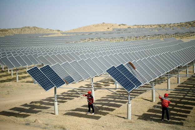 In einem Photovoltaik-Kraftwerk in Yinchuan, China, stauben Mitarbeiter nach windigem Wetter Photovoltaik-Paneele ab