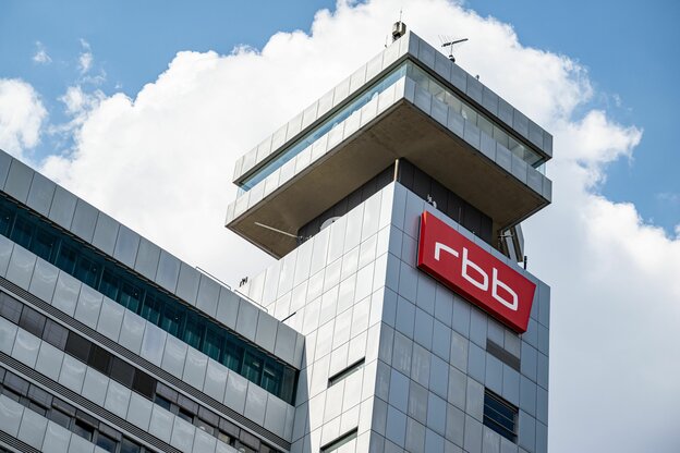 Ein weißes Bürogebäude mit dem roten rbb-Schild, im Hintergrund Himmel