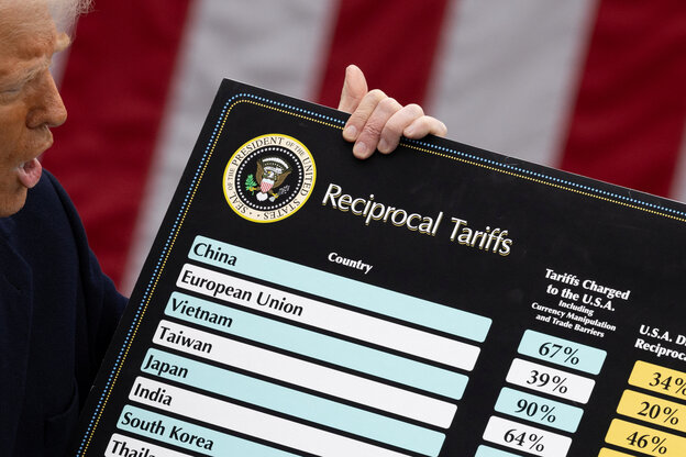Trump hält eine beschriftete Tafel vor die Kamera.