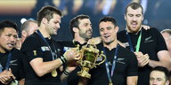 Die Spieler der neuseeländischen Rugby-Nationalmannschaft mit dem WM-Pokal