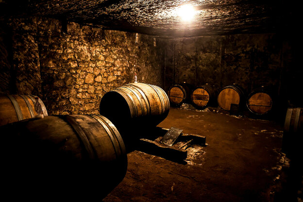 Weinfaesser in einem dunklen Keller