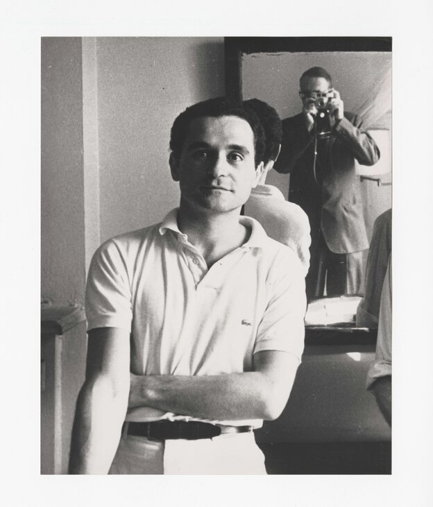 Porträt des jungen John Giorno im legendären Chelsea Hotel in New York, im Spiegel dahinter sieht man den Fotografen. Es ist der Schriftsteller William S. Burroughs