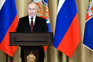 Putin steht an einem Rednerpult und spricht