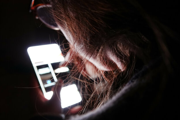 Eine junge Frau bedient ihr Smartphone (gestellte Szene)