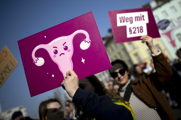 Demonstrierende halten Protestschilder mit der Aufschrift „Weg mit Paragraph § 218