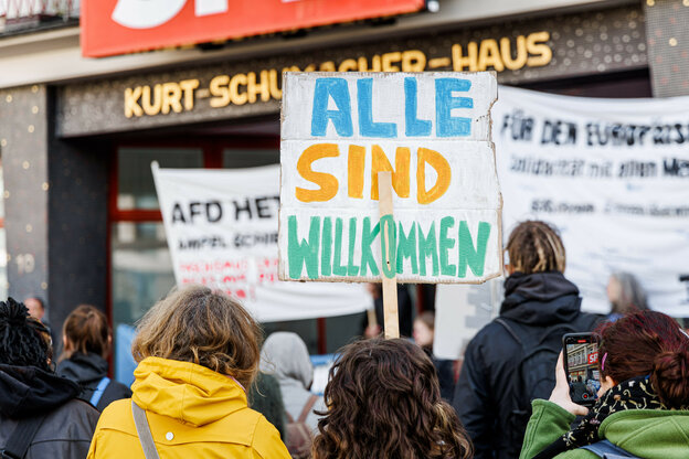 Menschen stehen mit einem Protestschild 