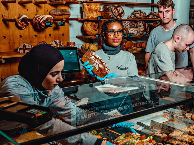 Mehrere Menschen stehen hinter der Ladentheke einer Bäckerei