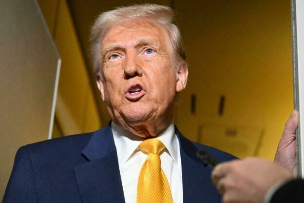 Donald Trump trägt einen Anzug mit einer gelben Krawatte