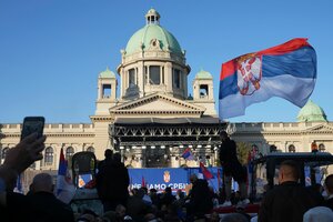 Protestmenge mit Fahnen vor einer Bühne