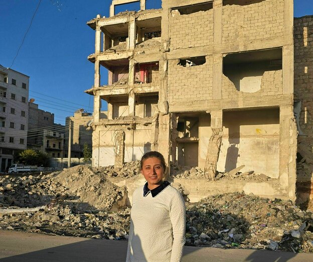 Eine Frau steht vor zerstörten Häuser in Ashrafiyeh