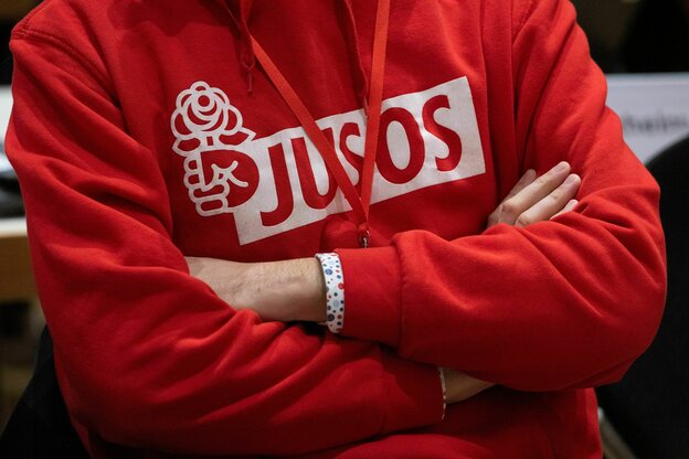Eine Person trägt einen roten Pullover mit der Aufschrift 