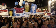 Menschen halten Schilder in der Hand, auf dem einen sind zwei Männer: der vor 20 Jahren ermordete Jitzhak Rabin und der heutige Regierungschef Netanjahu