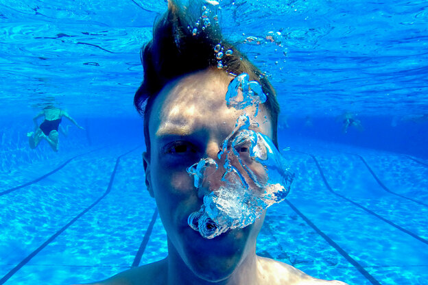 Ein Schwimmer pustet unter Wasser Blasen