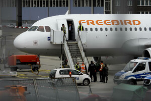 Polizisten bringen einen Mann in ein Flugzeug