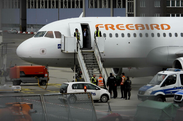 Polizisten bringen einen Mann in ein Flugzeug der türkischen Airline Freebird
