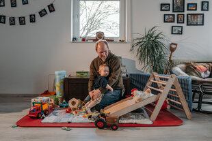 Lasse Brandt sitzt mit seinem kleinen Kind in der Spielecke in seiner Wohnung