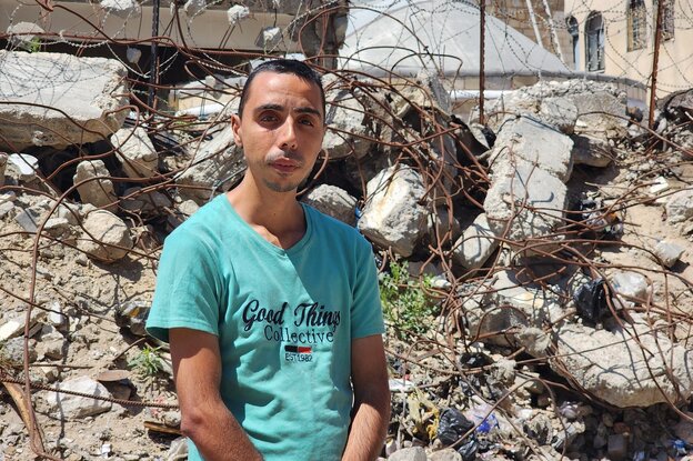 Ihab Ayad steht vor zerstörten Gebäuden