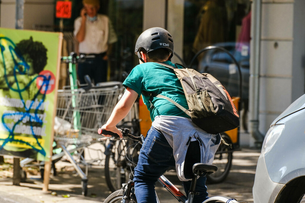 Ein Schüler auf seinem Fahrrad von hinten