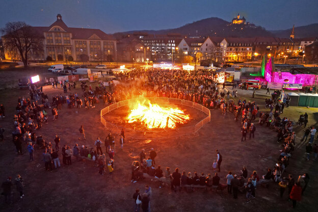 Ein großes Feuer um das in einigem Abstand Menschen stehen