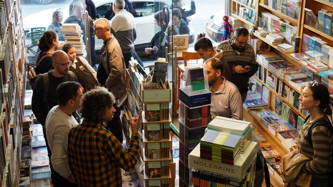 Viele Menschen in einem kleinen Buchladen