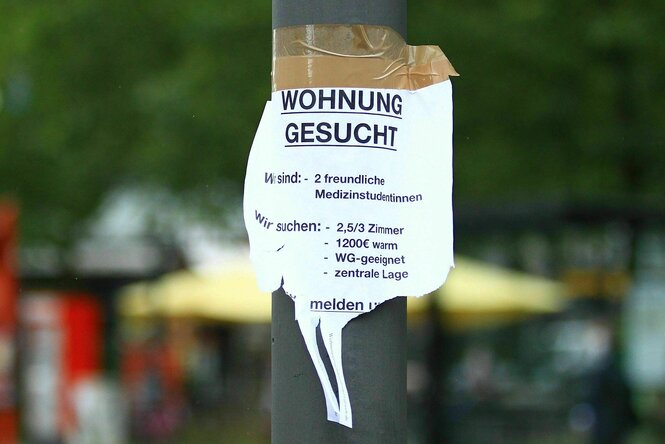 An einem Laternenpfahl hängt ein Zettel mit einem Wohnungsgesuch von zwei Medizinstudentinnen.