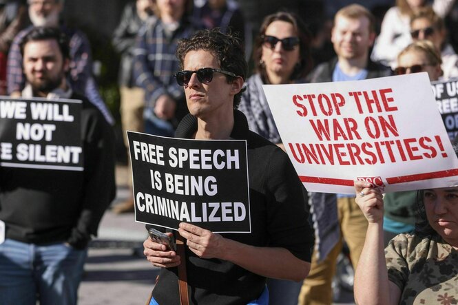 Protest gegen die Regierung: Menschen halten Schilder hoch mit Slogans wie: Stop war on universities