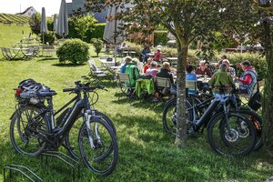 Eine Gruppe von E-Bike-Fahrer*innen isst zu Mittag in einem pfälzischen Weinlokal