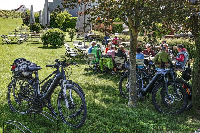 Eine Gruppe von E-Bike-Fahrer*innen isst zu Mittag in einem pfälzischen Weinlokal