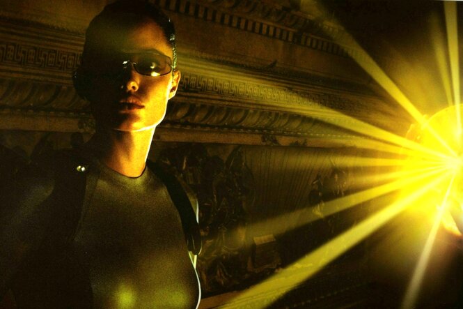 Lara Croft wird von den gelben Strahlen einer Lampe angestrahlt