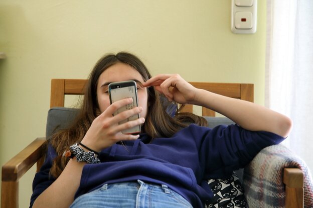 Eine Jugendliche hält ihr Smartphone vor ihr Gesicht