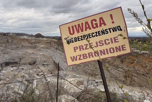 Ein Warnschild mit polnischer Aufschrift in einem Steinbruch