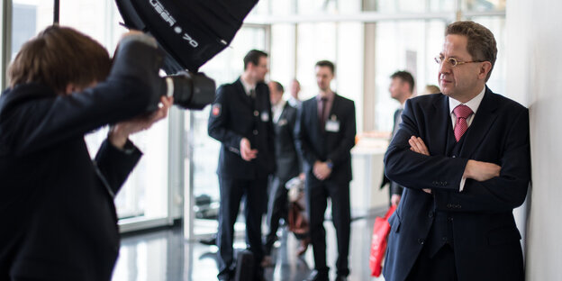 Ein Fotograf visiert mit seiner Kamera einen Mann im Anzug an, es ist Verfassungsschutzpräsident Hans-Georg Maaßen