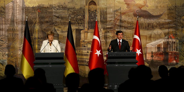Frau Merkel zwischen Deutschlandfahnen, daneben Herr Davutoglu zwischen Türkeifahnen