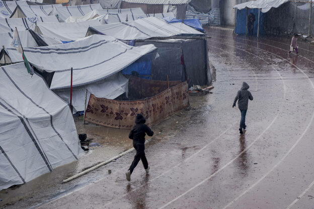 Eine verregnete Stadionlaufbahn am Rand einer Zeltstadt für Flüchtlinge