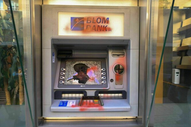 zerstörter Bankautomat, mit roter Farbe beschmiert, der Bildschirm zerschmettert
