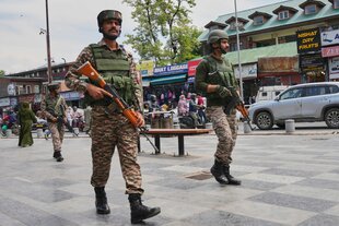 Indische paramilitärische Soldaten patrouillieren auf einem belebten Markt in Srinagar im indisch kontrollierten Kaschmir