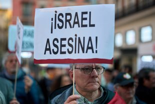 Ein pro-palästinensischer Demonstrant hält bei einem Protestmarsch in Madrid im März ein Schild mit der Aufschrift "Israel tötet"
