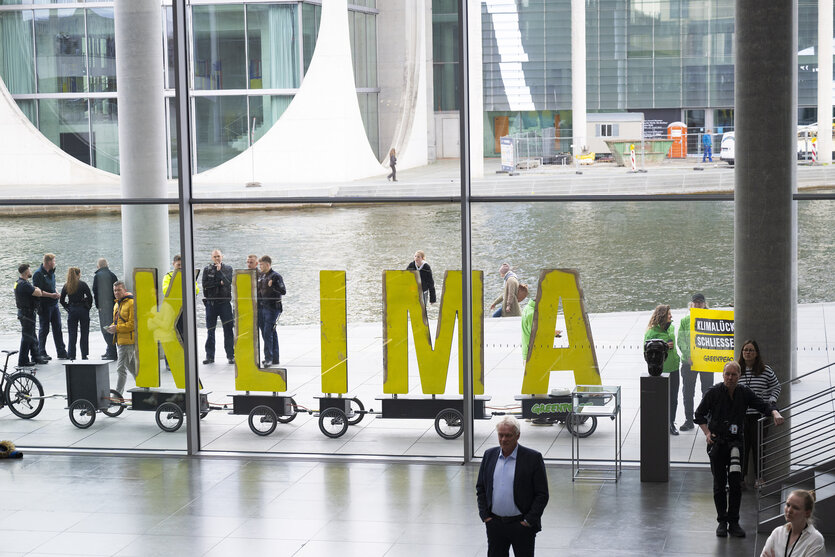 Klimaaktivisten stehen mit gelben Buchstaben des Wortes Klima vor dem Paul-Löbe Haus - die Polizei sit auch unterwegs
