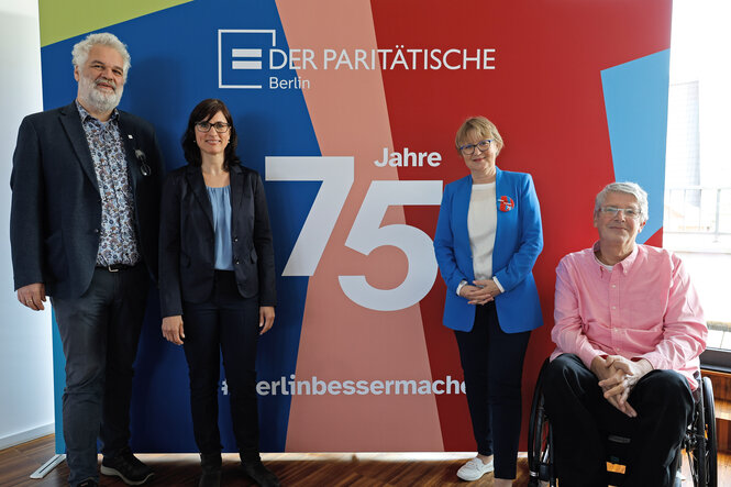 Vier Vertreter*innen des Berliner Paritätischen Wohlfahrtsverbandes vor einer Pressewand