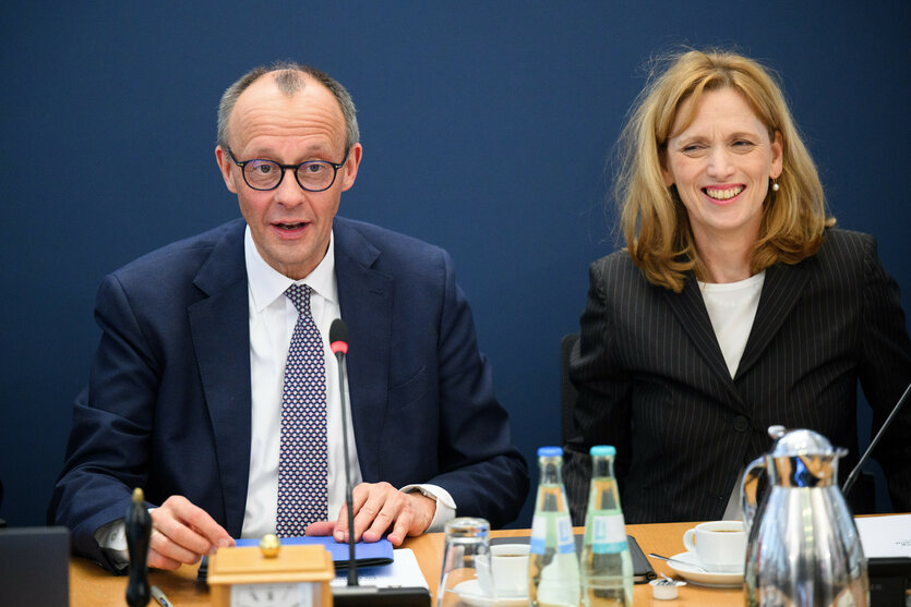 Friedrich Merz und Karin Prien sitzen lächelnd nebeneinander