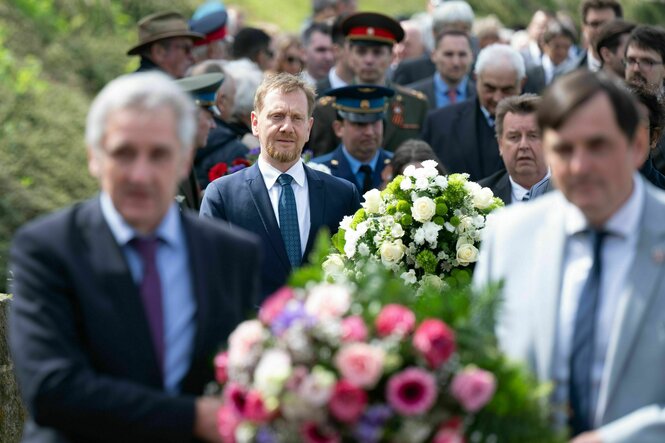 Michael Kretschmer (CDU, 2.v.l.) legt während einer Gedenkveranstaltungen zum 80. Jahrestag des Kriegsendes einen Kranz am Denkmal der Begegnung nieder