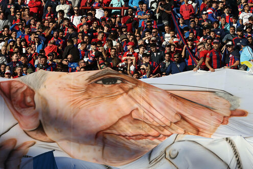 Papst Banner vor eienr Menge von Fußballfans