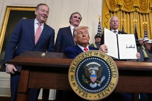 US-Präsident Donald Trump hält ein unterschriebes Dokument hoch. Hinter ihm stehen weitere Regierungspolitiker.