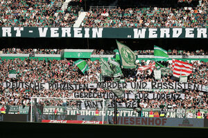 Werder-Fans mit Transparenten und Fahnen im Stadion.