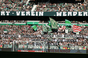 Werder-Fans mit Transparenten und Fahnen im Stadion.