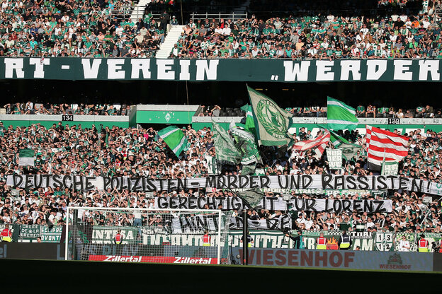 Werder-Fans mit Transparenten und Fahnen im Stadion.