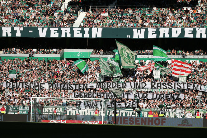 Werder-Fans mit Transparenten und Fahnen im Stadion.