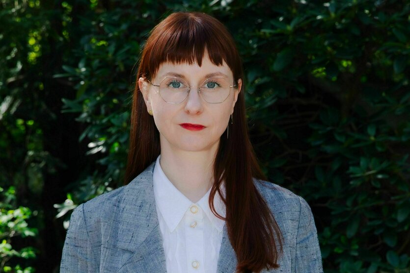Kathleen Reinhardt hat dunkles langes Haar und einen Pony